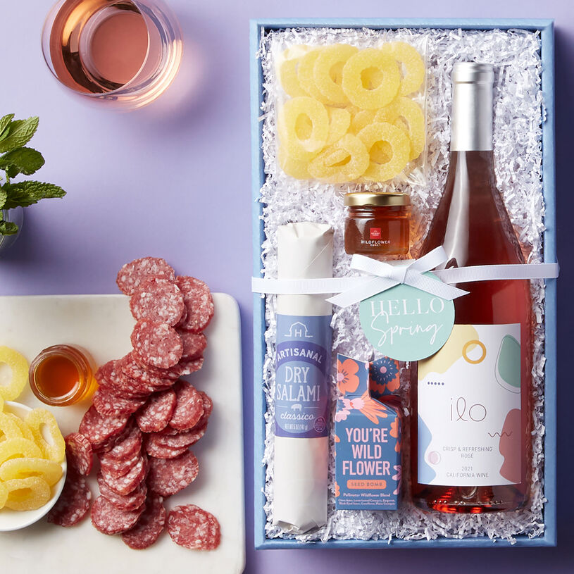 This spring wine gift set features Classico Dry Salami, Wildflower Honey, Pineapple Rings, Modern Sprout You're Wild Seed Bomb, and Ilo California Rosé.