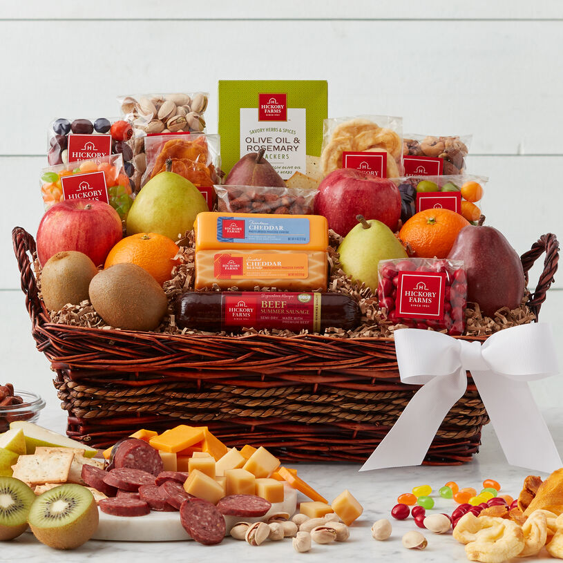This gift basket is filled with fruit, summer sausage, cheese, crackers, mixed nuts, dried fruit, and a cookie.