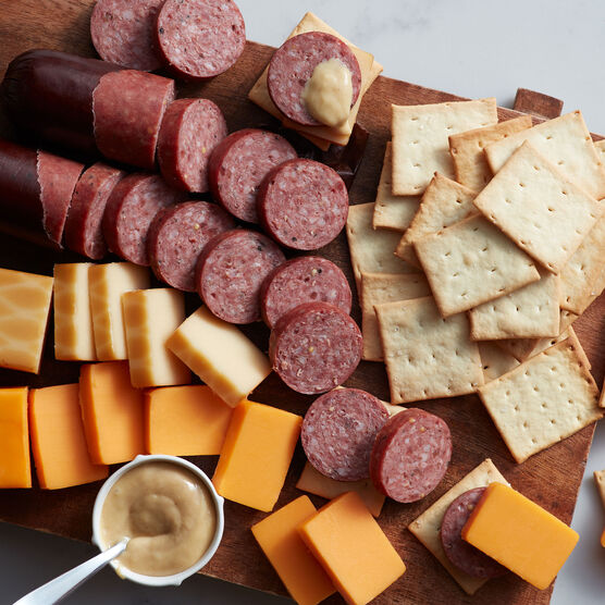 Alternate view of Hickory Farms sweet hot mustard on a charcuterie board with beef summer sausage, smoked cheddar, and farmhouse cheddar cheese