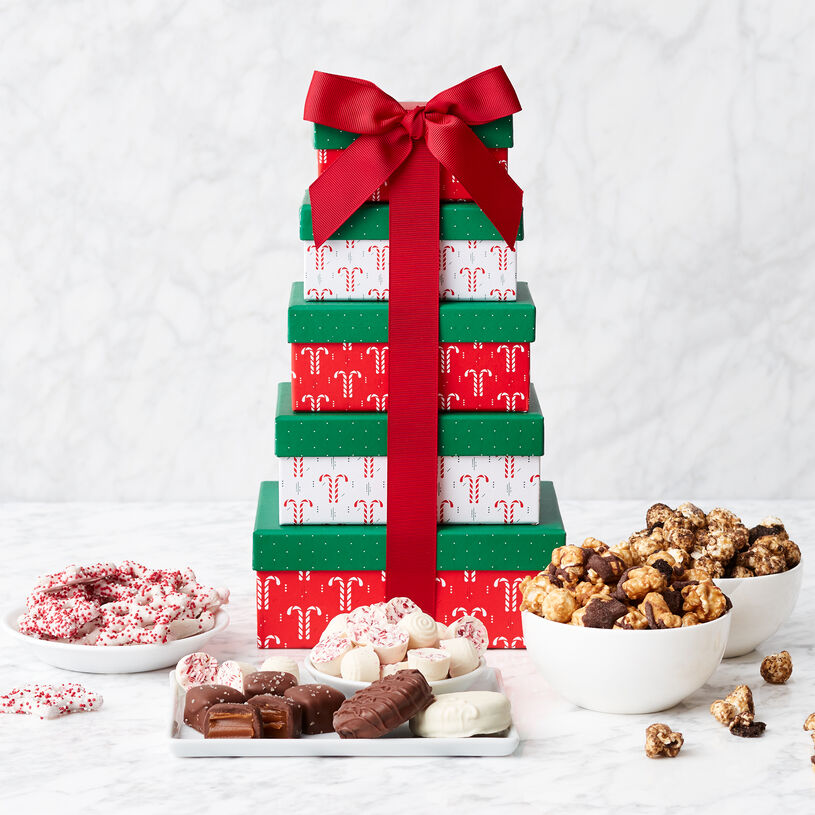 This gift tower includes five festive holiday boxes filled with Dark Chocolate Sea Salt Caramels, Snowflake Pretzels, Snow Mints, Popcorn, White Chocolate Covered Sandwich Cookie, and Milk Chocolate Covered Sandwich Cookie. 