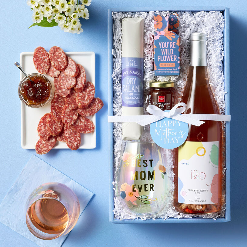 Collection of treats for Mom including Dry Salami, Strawberry Fig Jam, Ilo California Rosé, a Best Mom Ever Stemless Wine Glass, and Modern Sprout You're Wild Seed Bomb.