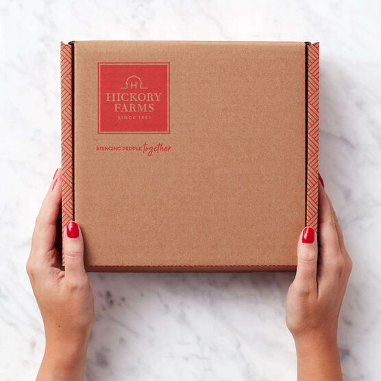 Hickory Farms mailer held by hands on marble background