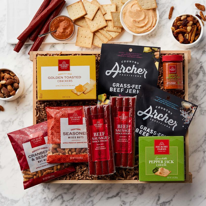 This crate is packed with Country Archer Original and Teriyaki Beef Jerky, Beef Sausage Snacks, Spreadable Pepper Jack Cheese, Spicy Sriracha Mustard, mixed nuts, and Golden Toasted Crackers. 