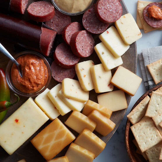 Alternate view of Hickory Farms sriracha mustatrd on a charcuterie board with beef summer sausage, jalapeno cheddar cheese, and smoked cheddar