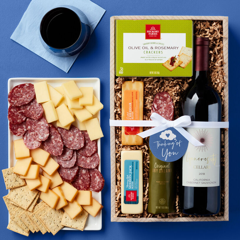 Thinking of you snack collection with dry salami, cheese, crackers, and wine.