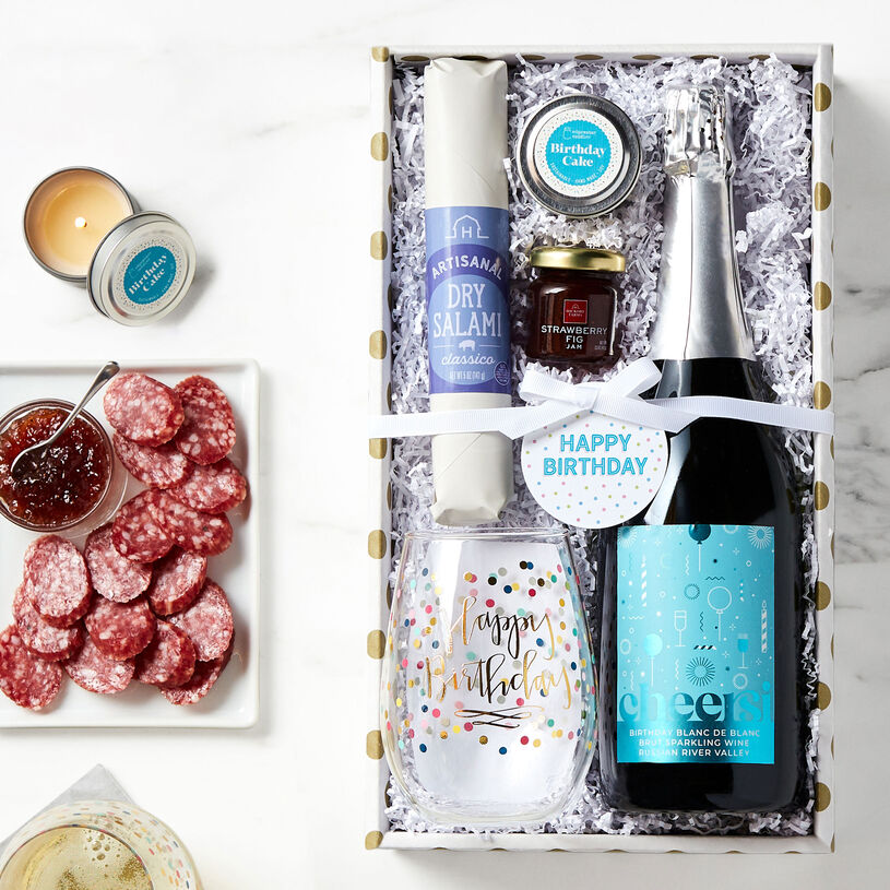 Gift basket features Classico Dry Salami, Strawberry Fig Jam, Cheersi Blanc de Blanc Brut Sparkling Wine, Birthday Cake Candle and a Happy Birthday Wine Tumbler