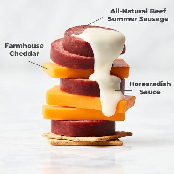 Stack of All-Natural Beef Summer Sausage with cheese & sauce