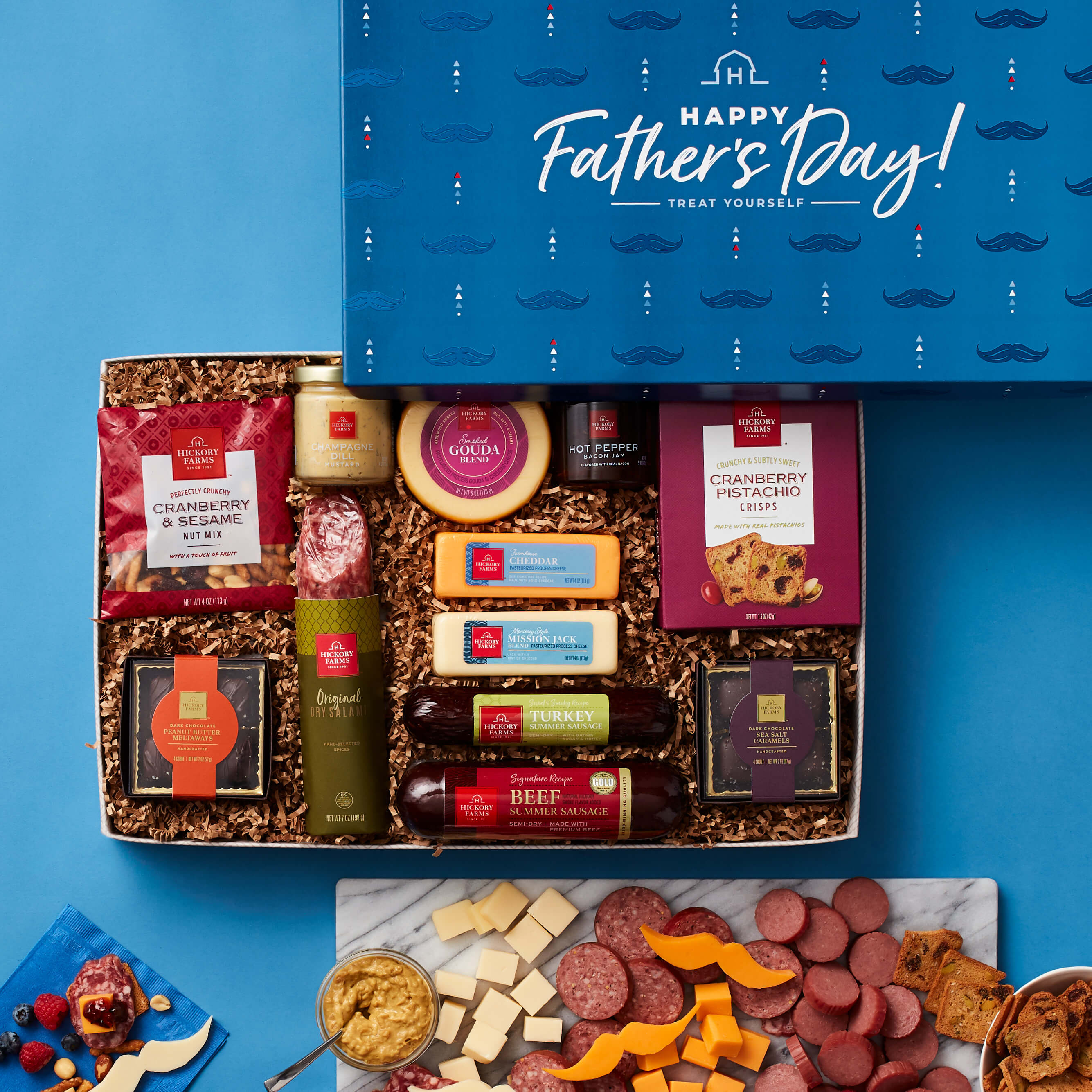 A Hickory Farms gift box with meat, cheese, chocolates, crackers, and condiments in a Father's Day gift box