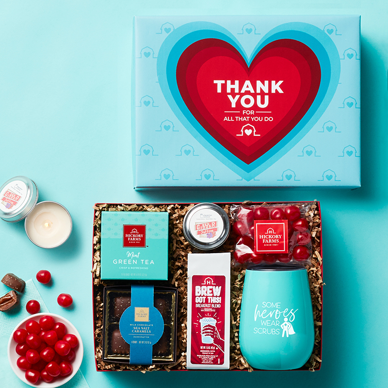 A photo of an opened thank you gift for healthcare workers, featuring a motivational tumbler, tea, coffee, and sweets.