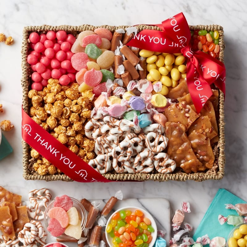 A photo of a gift basket filled with sweets like chocolate covered pretzels, toffee, jelly beans and caramel kettle corn