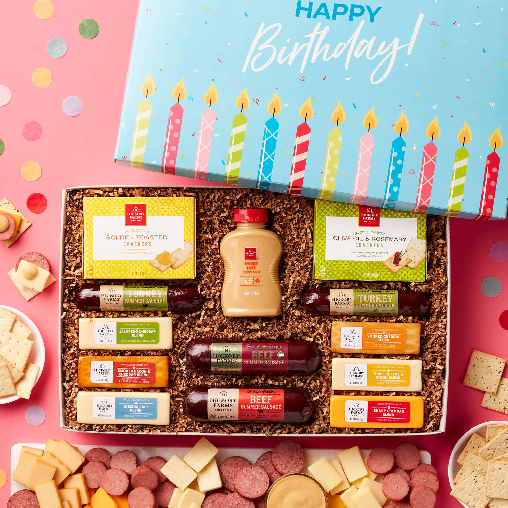The Birthday Hearty Party Gift Box includes beef, turkey, and spicy sausages, mustard, crackers, and various cheeses