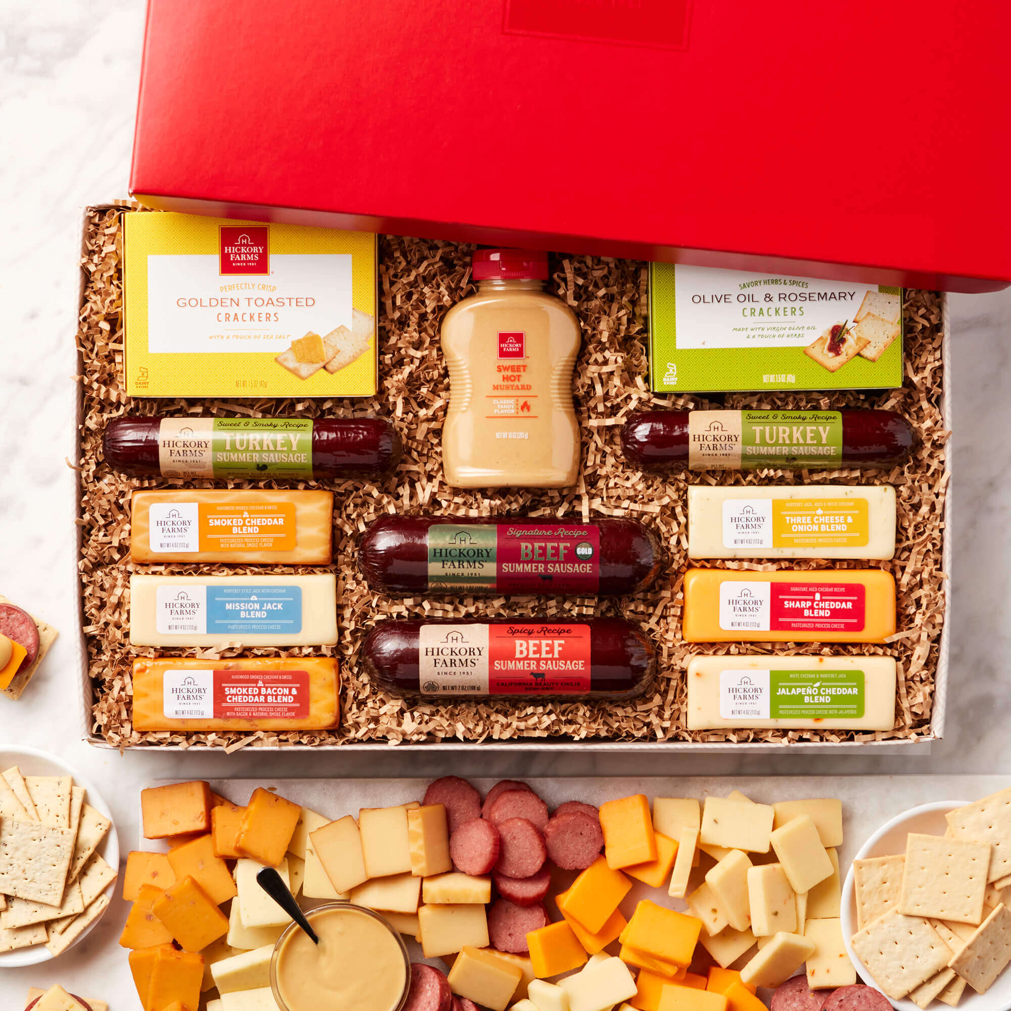 The Hearty Party Gift Box includes various beef, turkey, and spicy sausages, mustard, crackers, and various cheeses