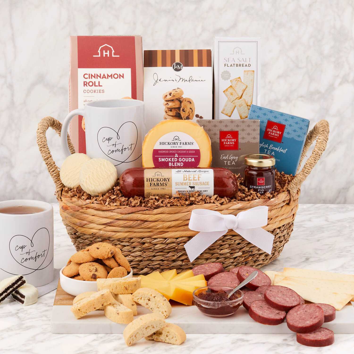 The Love and Comfort Gift Basket includes beef sausage, gouda cheese, flatbread crackers, cookies, and tea