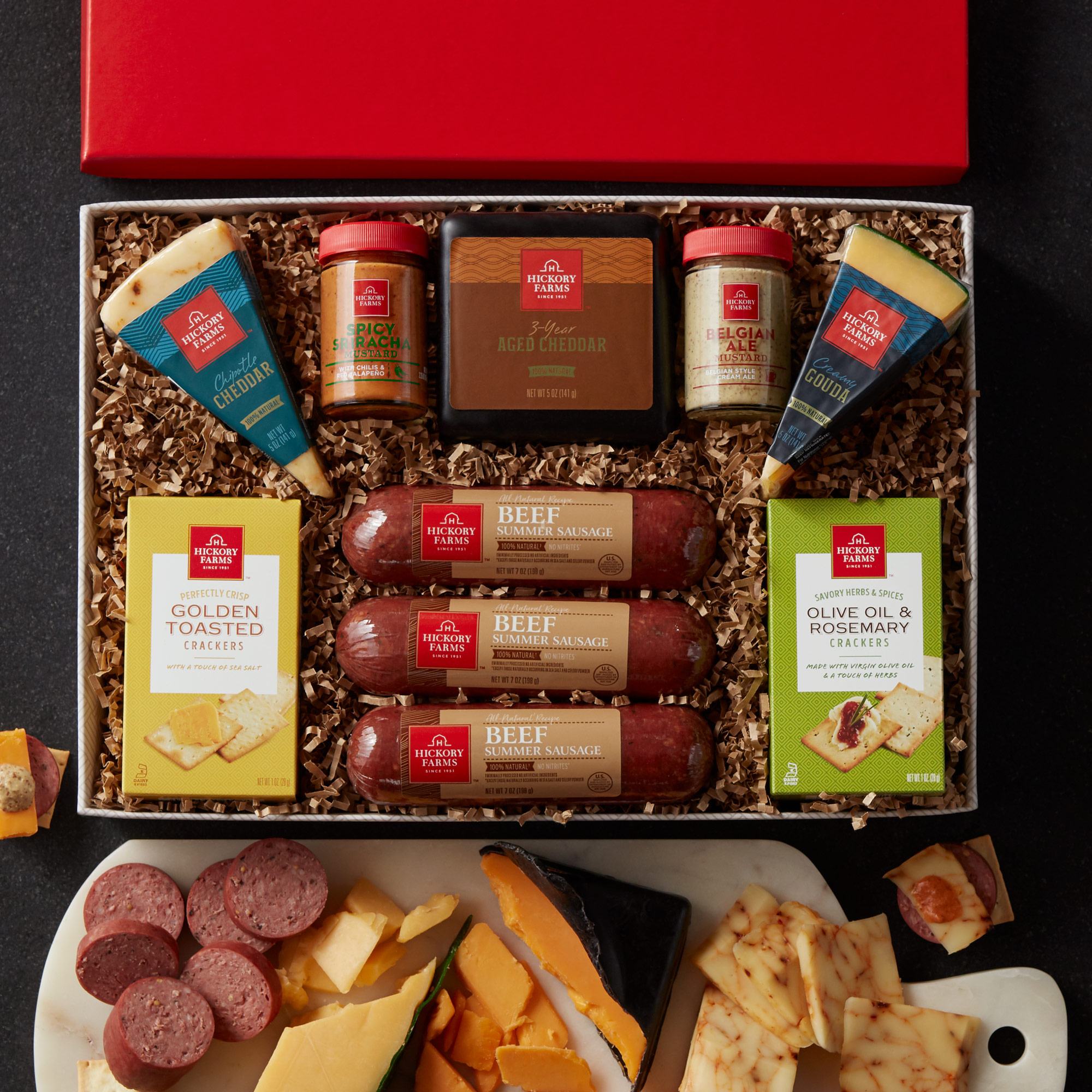 This gift box includes natural summer sausage, cheeses, mustard, and crackers.