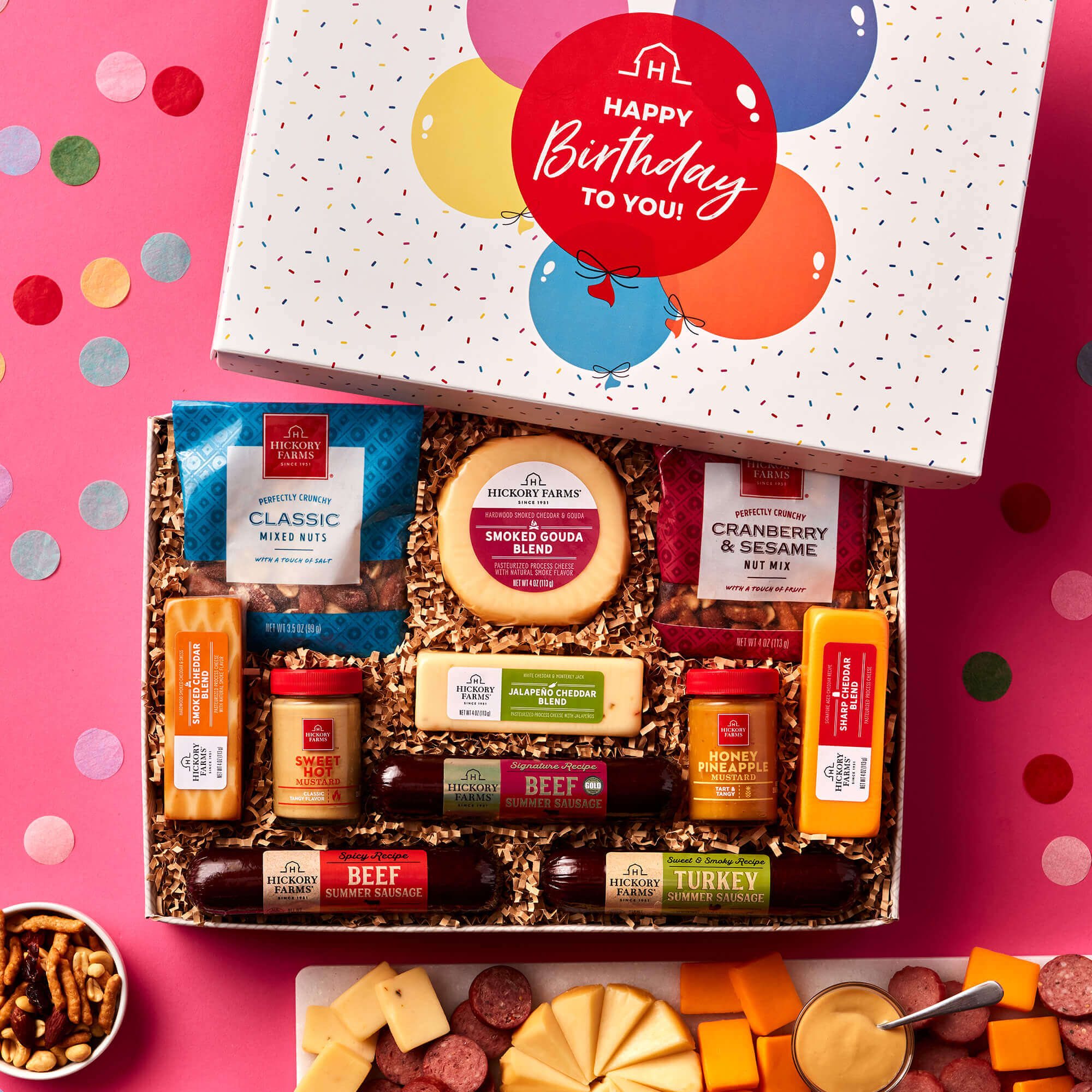 The Happy Birthday Give Back Gift Box includes beef, turkey, and spicy sausages, mustard, nuts, and various cheeses
