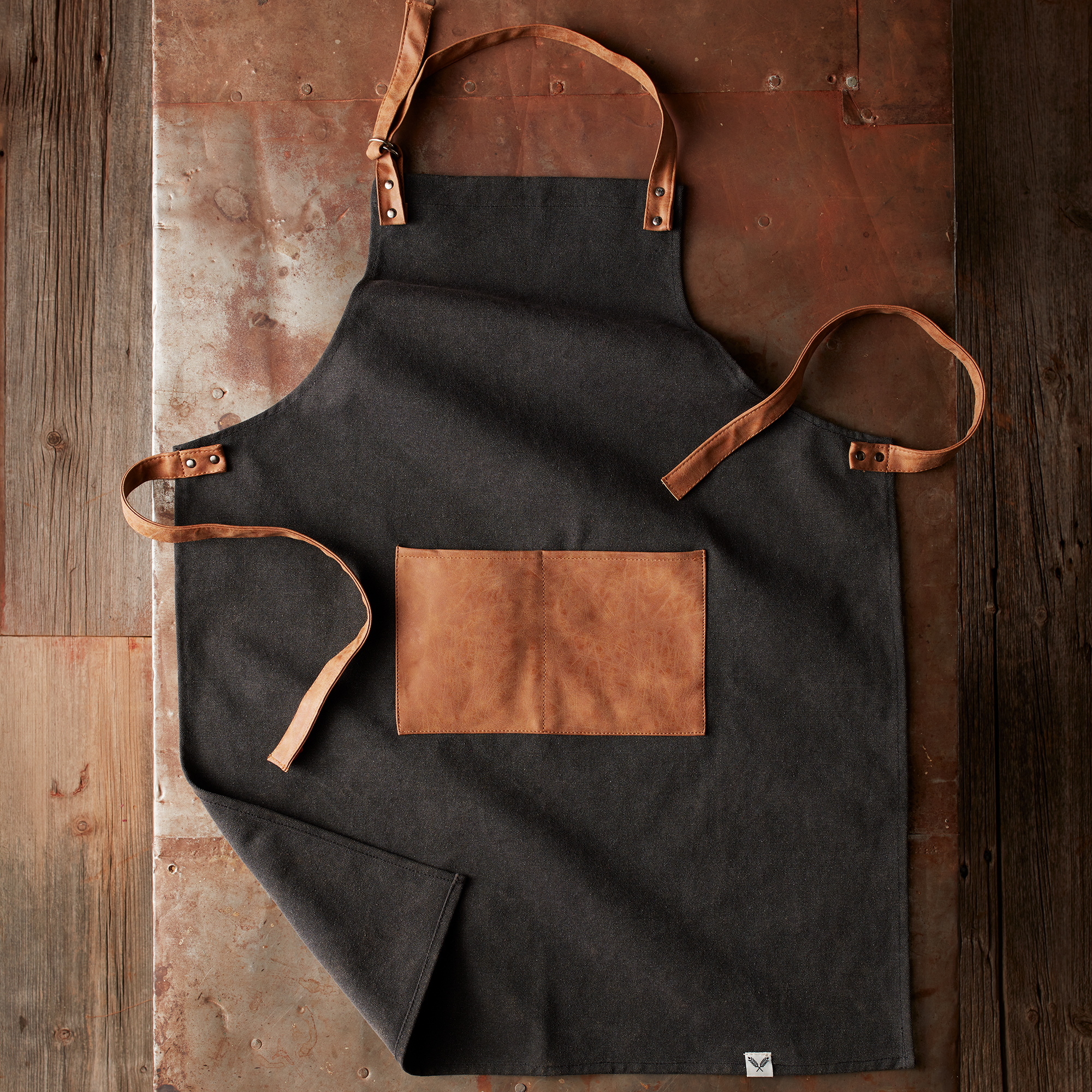Made of durable black canvas with faux leather straps and pocket, this apron will keep your favorite grillmaster clean and stylish at every barbeque