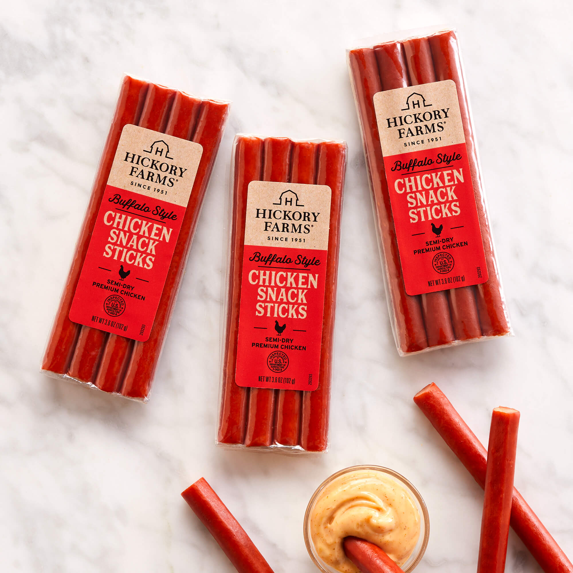 Buffalo Style Chicken Snack Sticks in packaging on a marble background