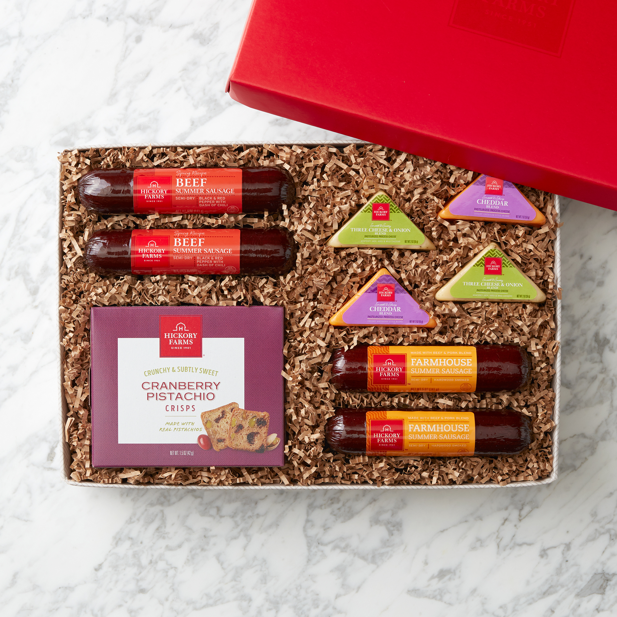 Spicy Beef and Farmhouse Summer Sausages, Smooth & Sharp Cheddar Blend, Three Cheese & Onion Blend, and Cranberry Pistachio Crisps.