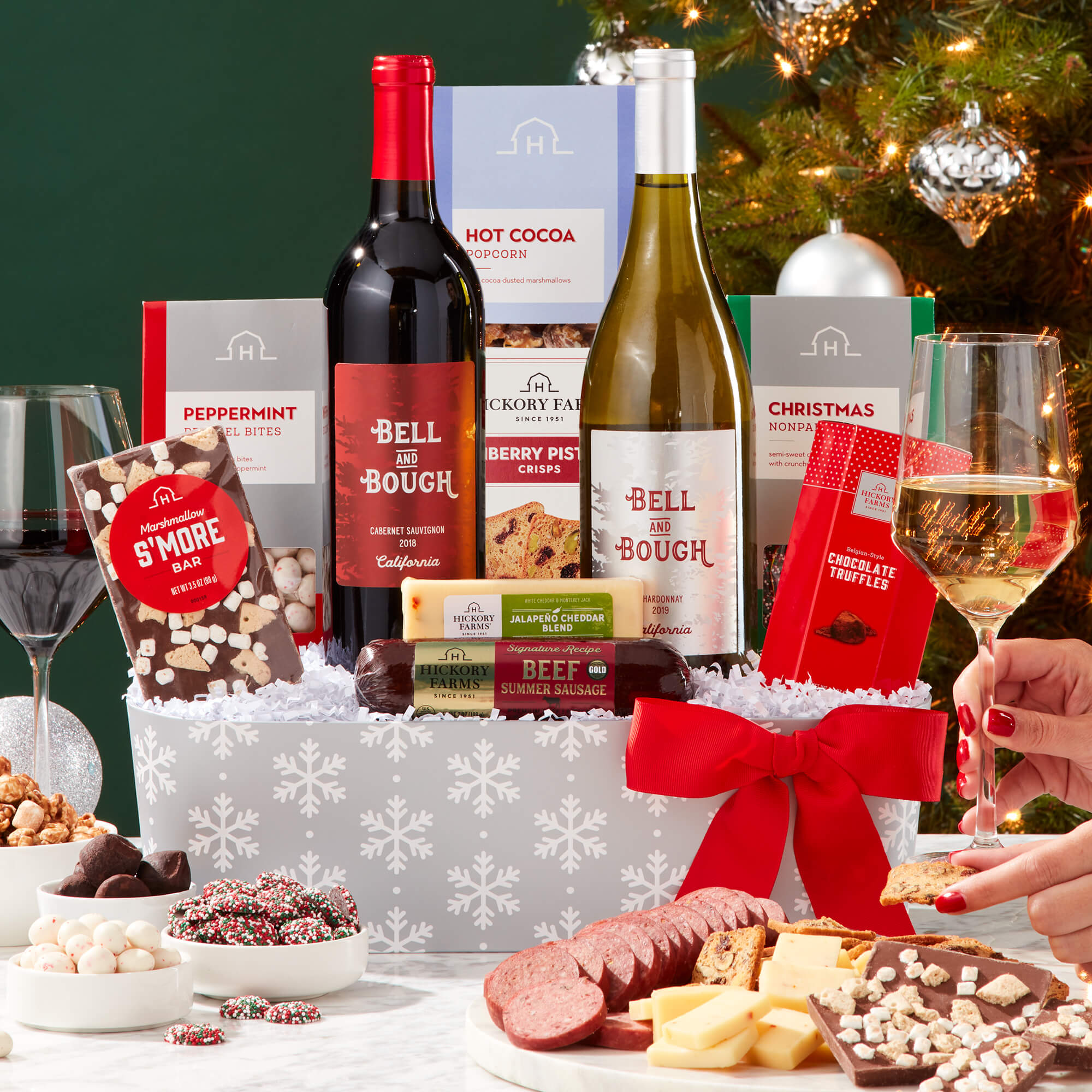 Holly Jolly Holiday Wine Gift Basket includes beef sausage, cheese, crackers, pretzels, popcorn, chocolate, and wine