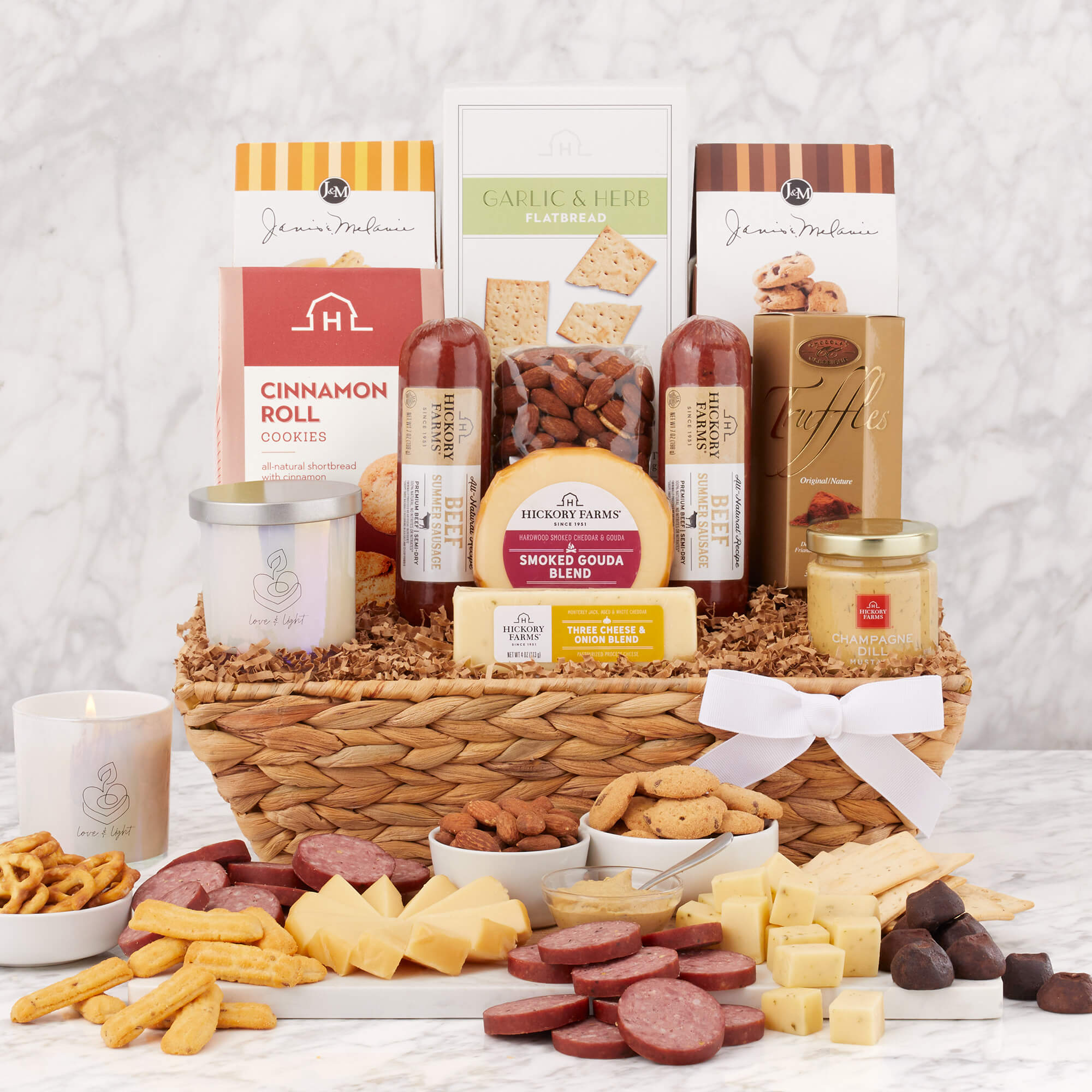 Love & Light Gift Basket includes two sausages, various cheeses, crackers, cookies, pretzels, and a candle